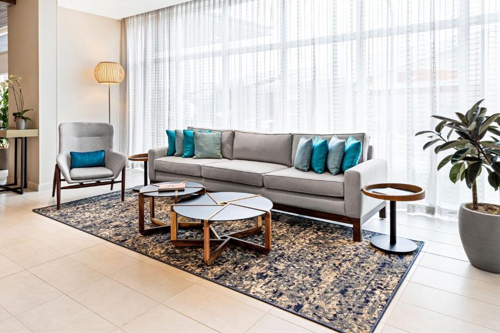 a living room with a couch and two chairs at Fairfield by Marriott San Jose Airport Alajuela in Alajuela City