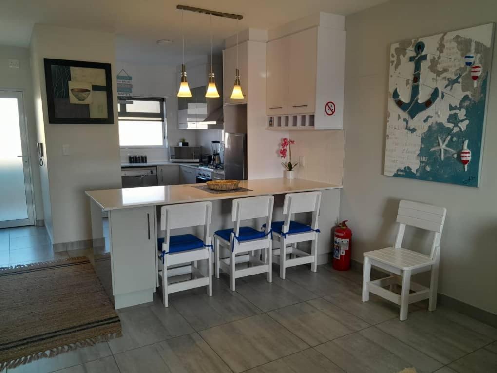 a kitchen with a island with chairs and a counter at Bright & Stylish in City Centre Swakopmund in Swakopmund