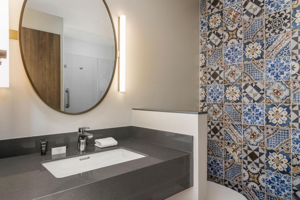 a bathroom with a sink and a mirror at Fairfield by Marriott San Jose Airport Alajuela in Alajuela City