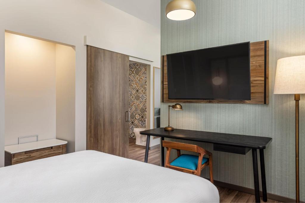 a bedroom with a bed and a desk with a television at Fairfield by Marriott San Jose Airport Alajuela in Alajuela City