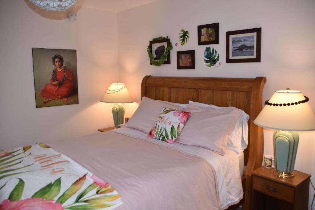 Seabank House Bed and Breakfast Aloha في بيكتو: غرفة نوم بسرير مع مصباحين وصور على الحائط