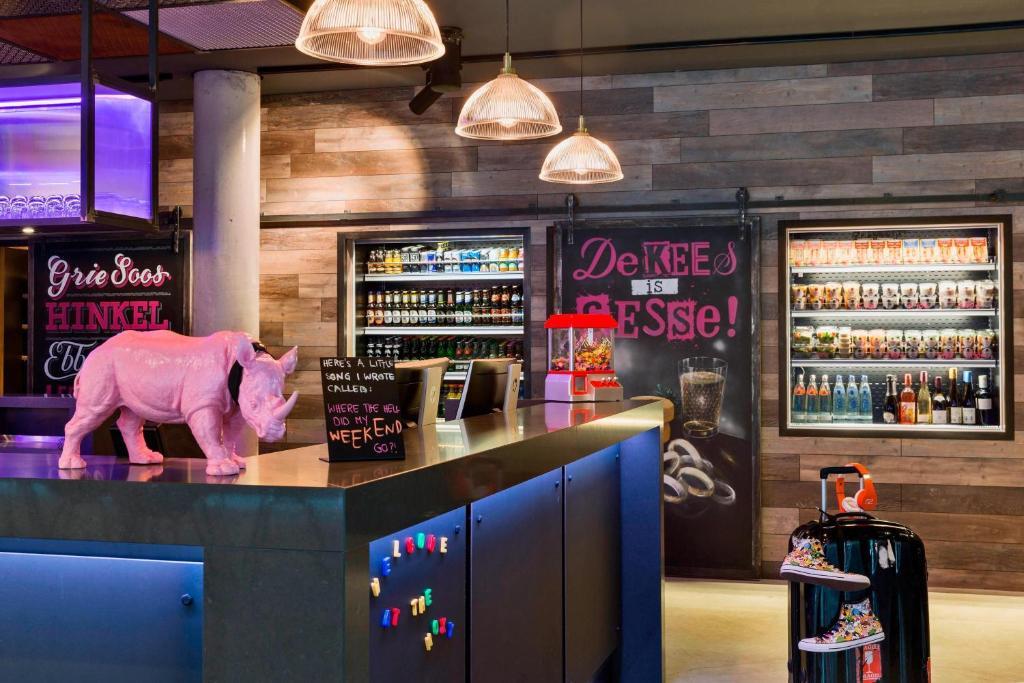 un jouet de porc rose assis sur un comptoir dans un bar dans l'établissement MOXY Frankfurt East, à Francfort-sur-le-Main