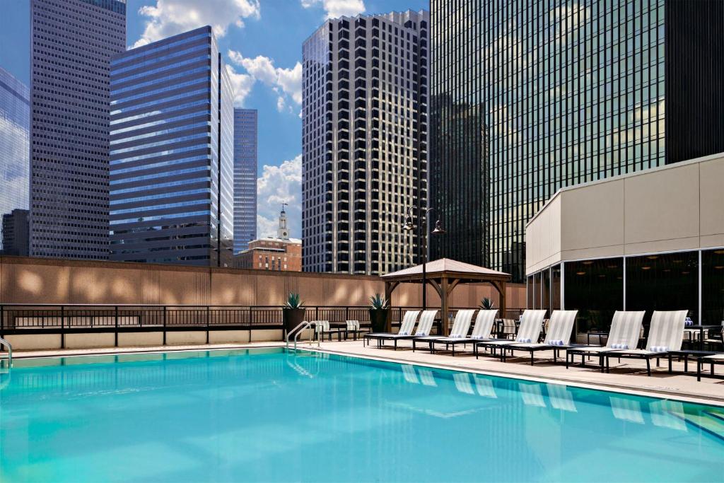 a large swimming pool with chairs and buildings at Sheraton Dallas Hotel in Dallas