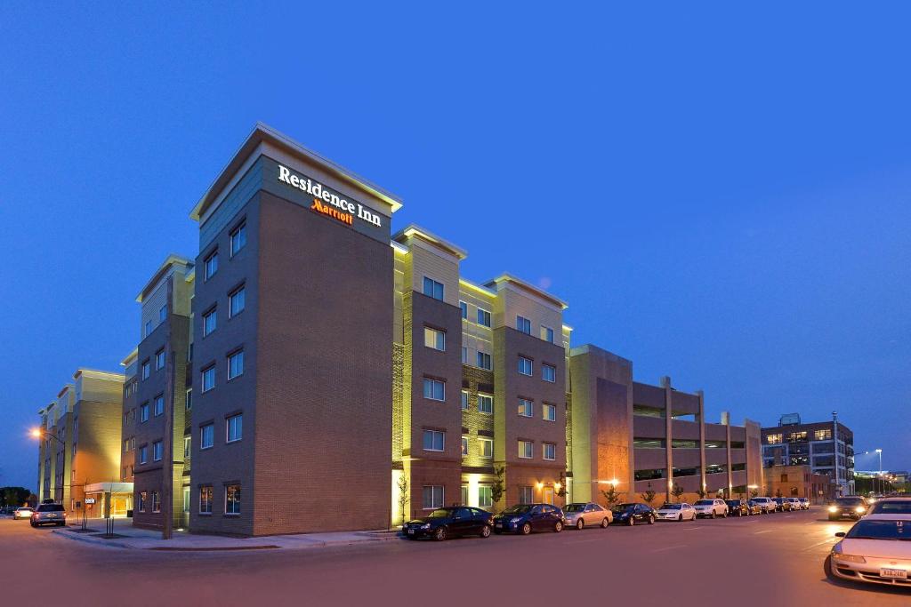 Residence Inn by Marriott Des Moines Downtown في دي موين: مبنى الفندق مع وجود سيارات تقف في موقف للسيارات