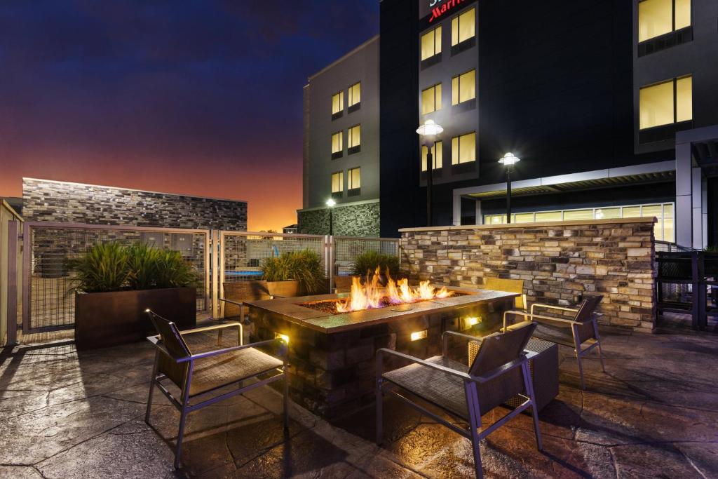 a patio with a fire pit and chairs and a building at SpringHill Suites by Marriott Midland Odessa in Midland