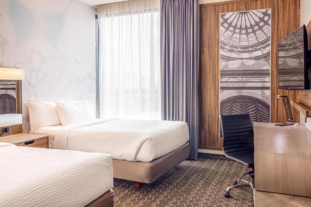 a hotel room with two beds and a window at Courtyard by Marriott Mexico City Vallejo in Mexico City