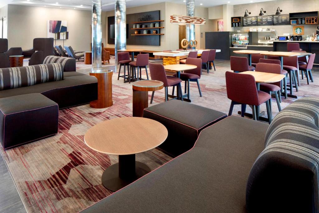 a waiting room with tables and chairs and tablesktop at Courtyard by Marriott Houston Intercontinental Airport in Houston