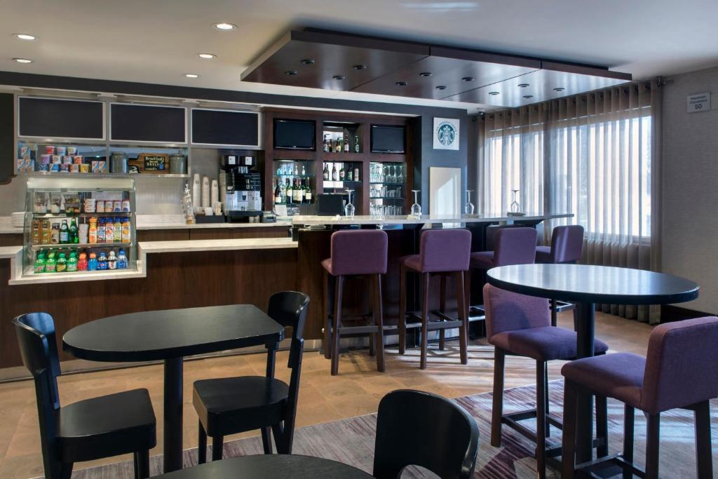 a bar in a restaurant with tables and chairs at Courtyard Newburgh Stewart Airport in Newburgh