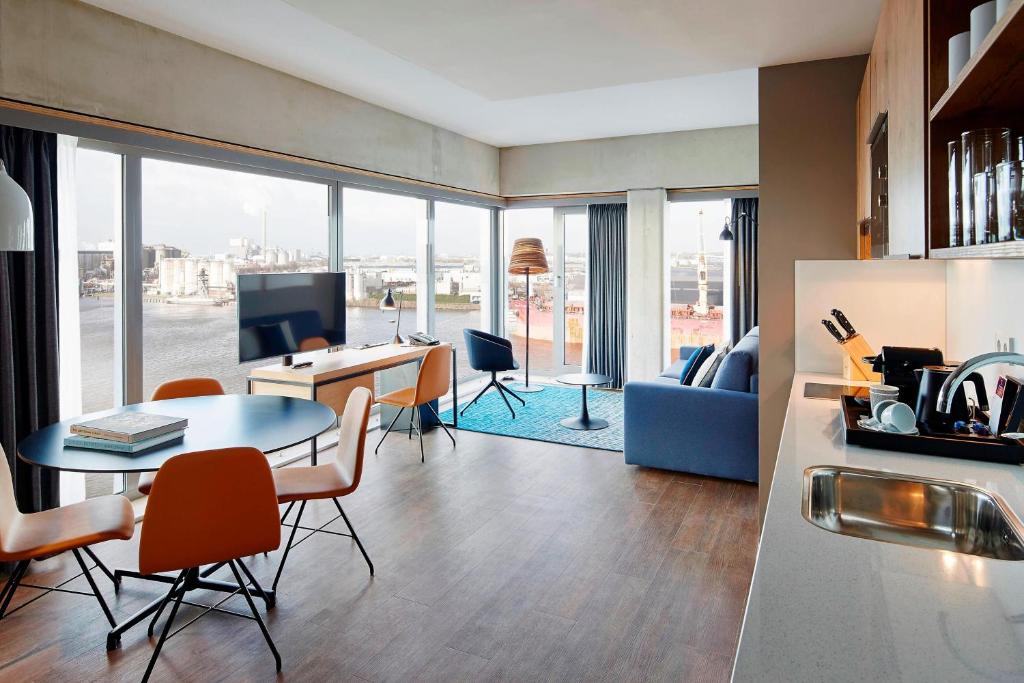 a living room with a table and chairs and a couch at Residence Inn by Marriott Amsterdam Houthavens in Amsterdam