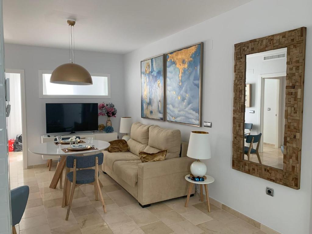 een woonkamer met een bank en een tafel bij Coral Oro en la Caleta Ha Apartment in Cádiz