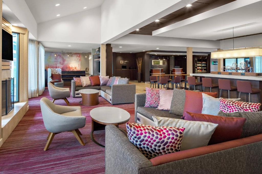 a lobby with couches and chairs and a bar at Courtyard by Marriott Pittsburgh Airport in Coraopolis