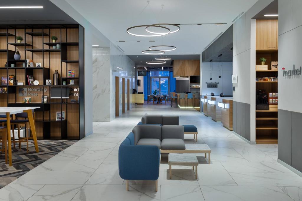 un hall avec des chaises et des tables ainsi qu'une salle à manger dans l'établissement Courtyard by Marriott Bucharest Floreasca, à Bucarest