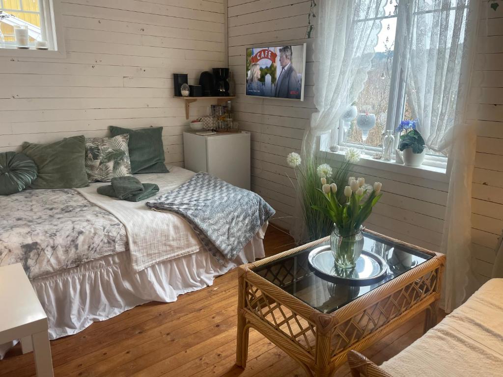 Un dormitorio con una cama y una mesa con flores. en Villa Angelica en Ljungskile