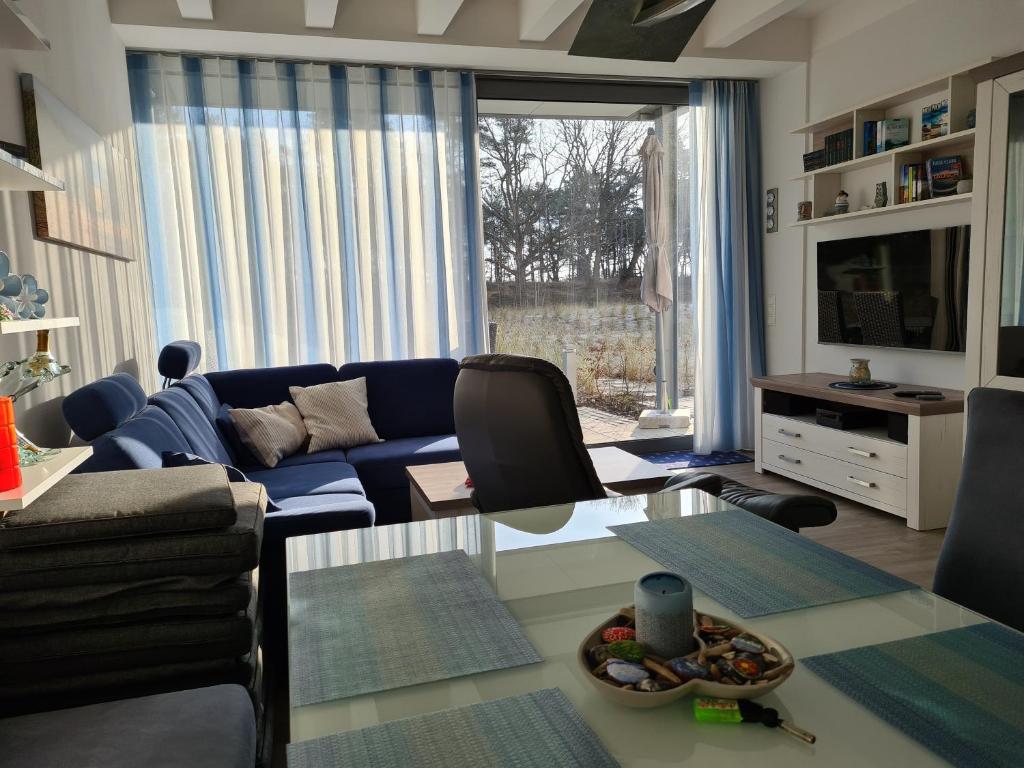 a living room with a blue couch and a table at FeWo Am Meer Prora in Binz