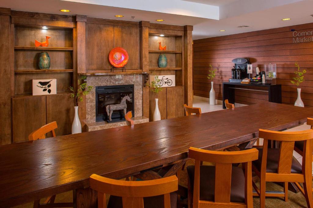 Fairfield Inn & Suites Lafayette I-10 في لافاييت: غرفة طعام مع طاولة وكراسي خشبية كبيرة