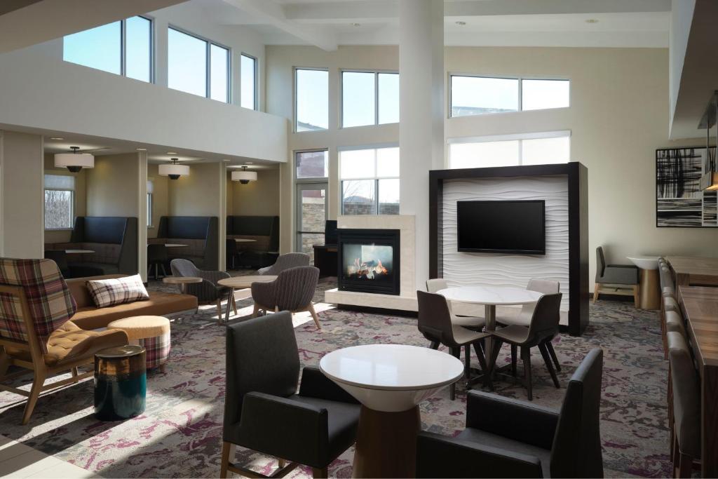 a hotel lobby with a fireplace and furniture at Residence Inn by Marriott Grand Rapids Airport in Grand Rapids