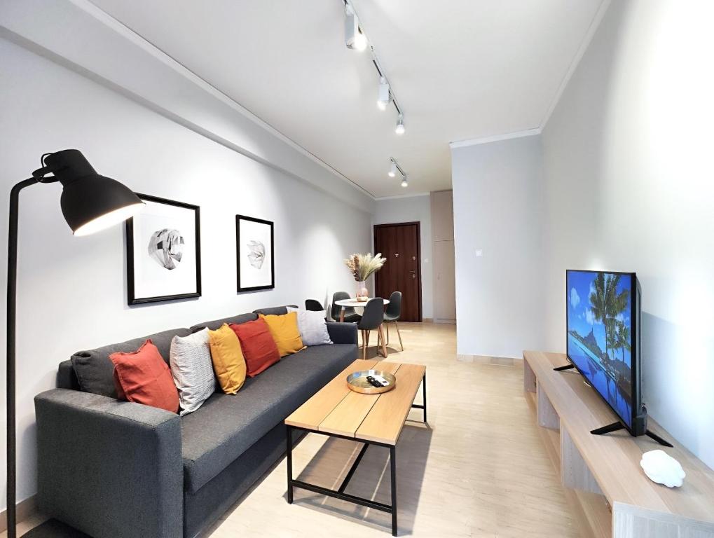 a living room with a couch and a tv at Dimitsanas by Verde Apartments in Athens