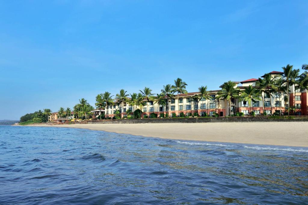 una spiaggia con una fila di case e palme di Goa Marriott Resort & Spa a Panaji
