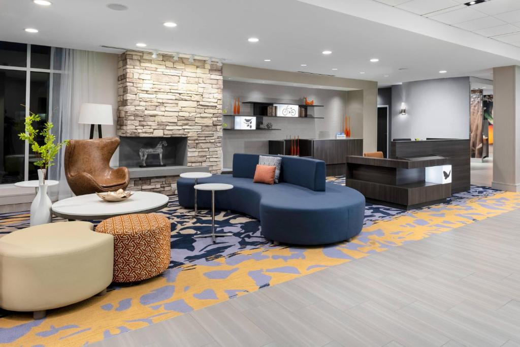 a lobby with a blue couch and a fireplace at Fairfield Inn & Suites Charlotte Pineville in Charlotte