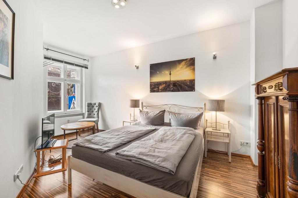 a bedroom with a bed and a desk and a window at Budget Apartment am Fernsehturm in Berlin