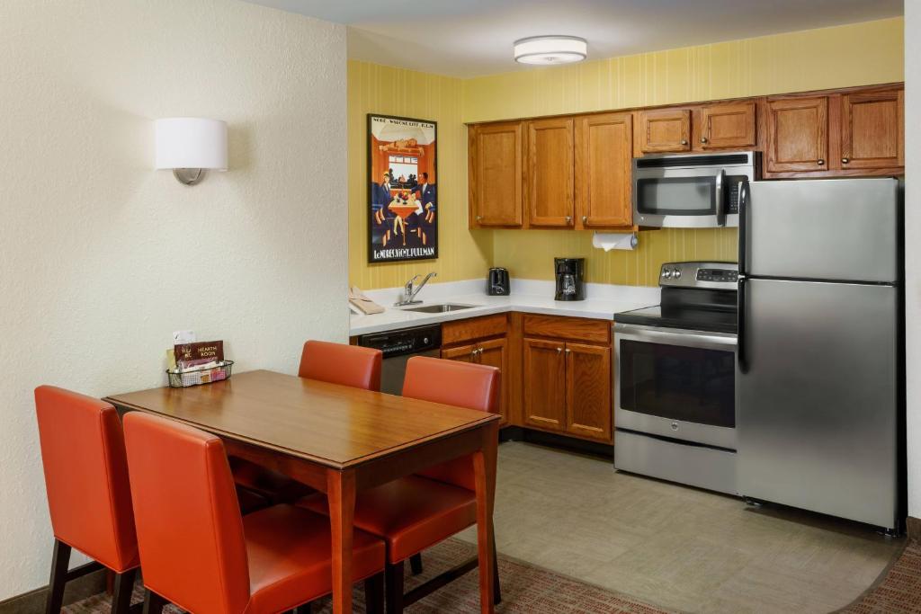 a kitchen with a wooden table and a stainless steel refrigerator at Residence Inn Houston Downtown/Convention Center in Houston