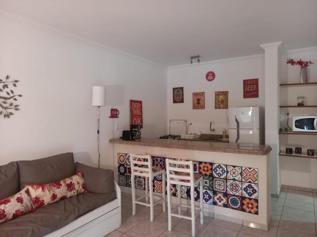 uma sala de estar com um sofá e uma cozinha em Flat Amarilis und 110 Riviera de Sao Lourenco SP em Rivera de São Lourenço