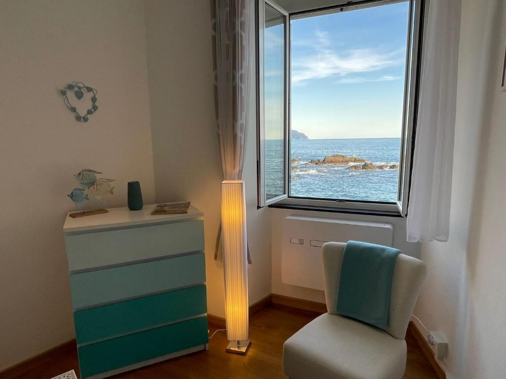 una camera con cassettiera, sedia e finestra di nel gozzo sul mare - Genovainrelax a Genova