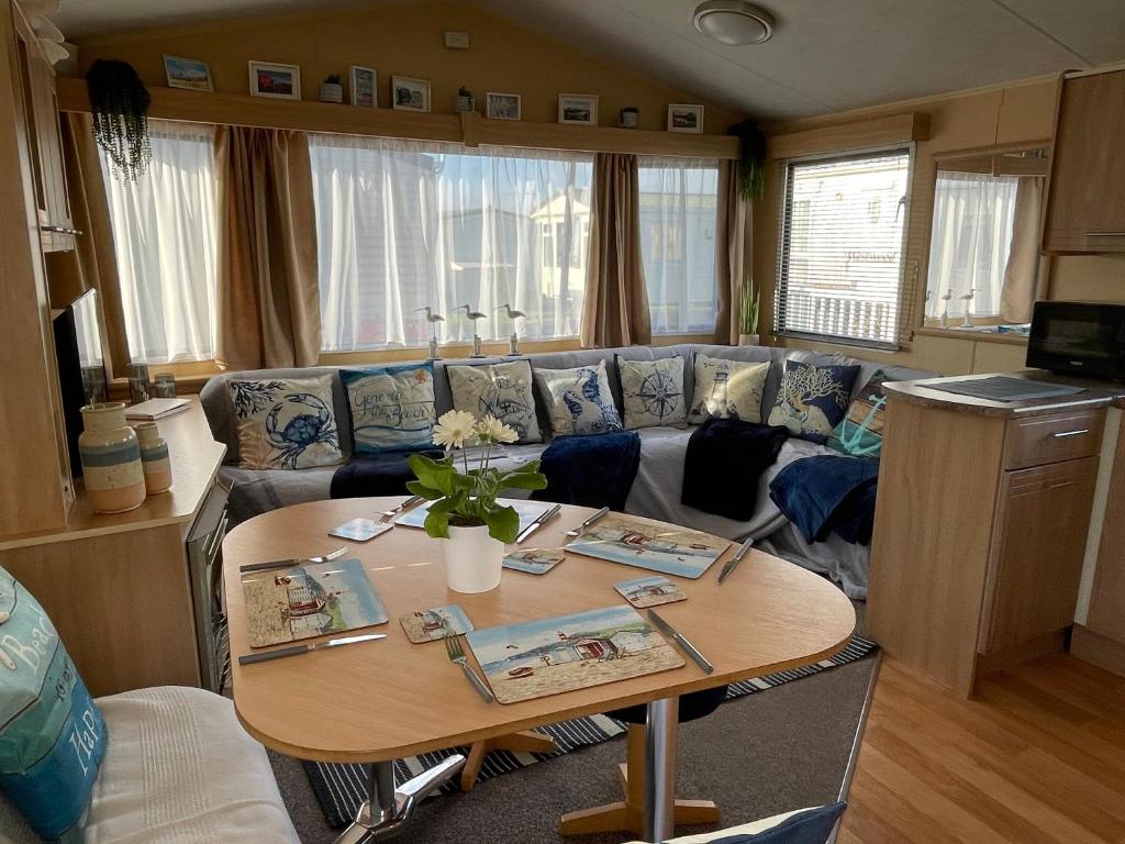 a living room with a couch and a table at Escape rio1 Caravan Seasalter Beach Outdoor Pool in Seasalter
