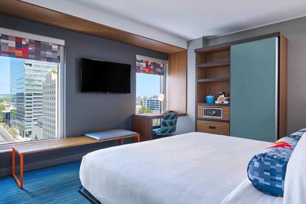 a hotel room with a bed and a large window at Aloft Austin Downtown in Austin