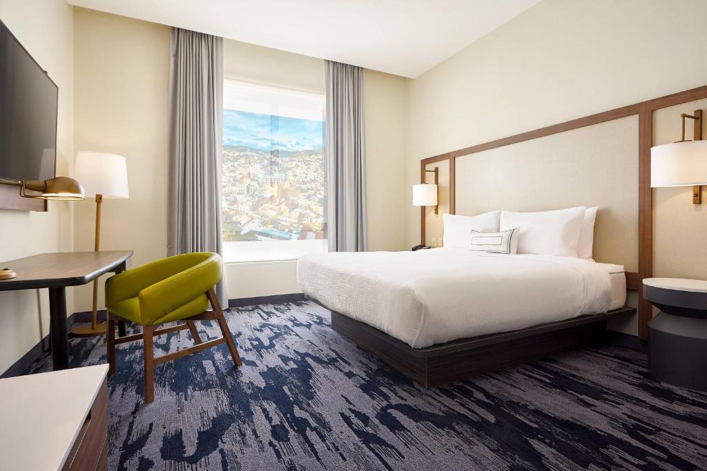 um quarto de hotel com uma cama, uma secretária e uma janela em Fairfield Inn & Suites Silao Guanajuato Airport em Silao