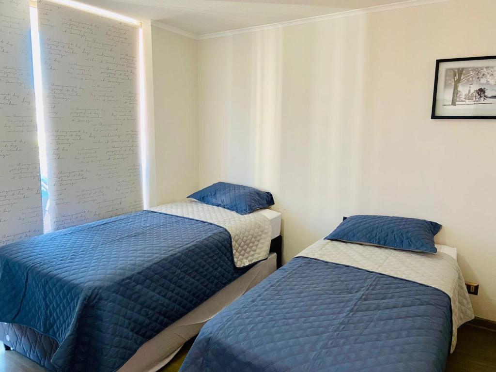two beds in a room with blue and white at Depto en Viña in Viña del Mar