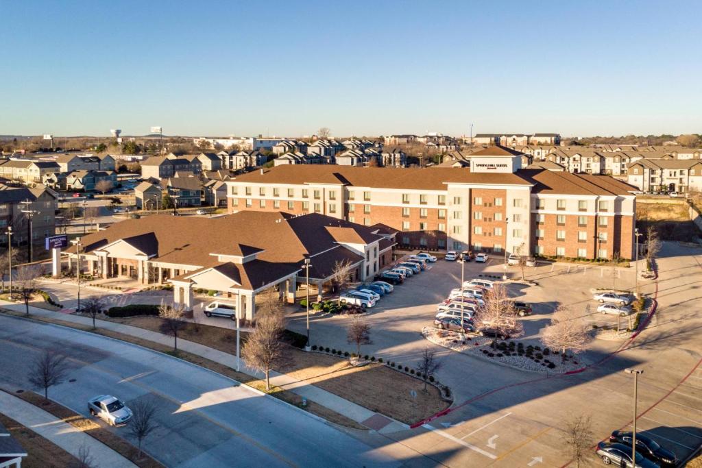 an aerial view of a city with buildings and a parking lot at SpringHill Suites by Marriott Denton in Denton