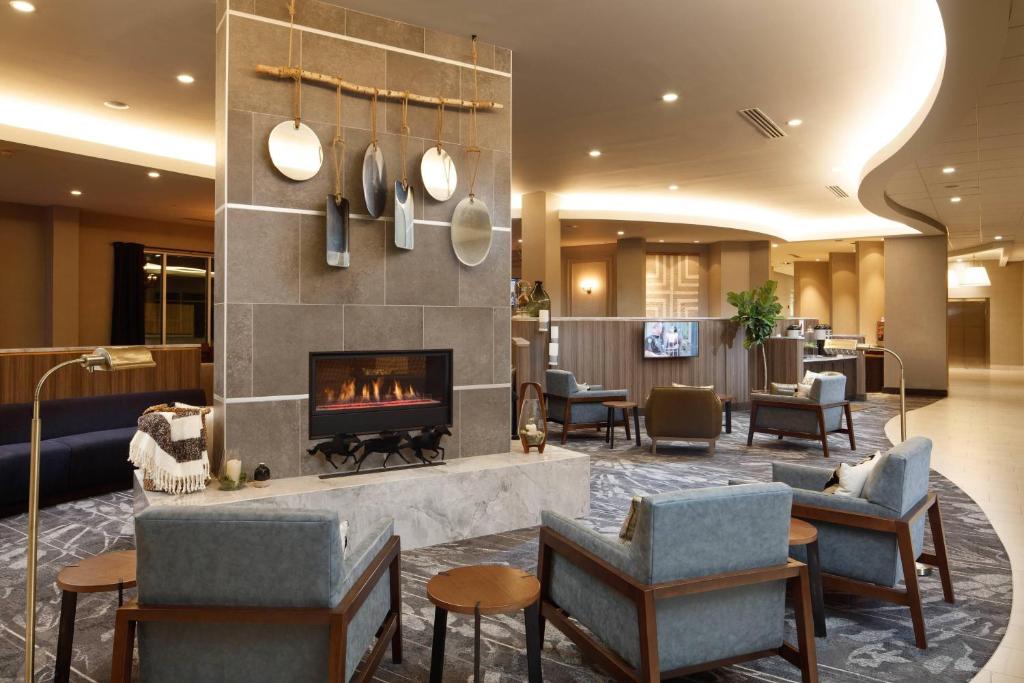 a hotel lobby with a fireplace and chairs at Fairfield Inn & Suites By Marriott Louisville Northeast in Louisville