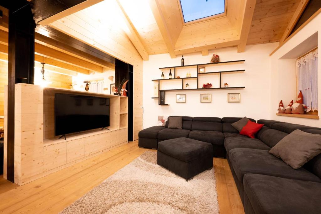 sala de estar con sofá y TV de pantalla plana en Ciasa Marta en Vigo di Fassa