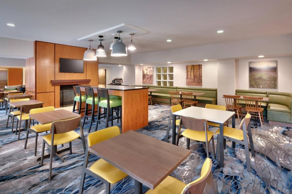 a restaurant with tables and chairs and a bar at Fairfield Inn & Suites Seattle Bellevue/Redmond in Bellevue