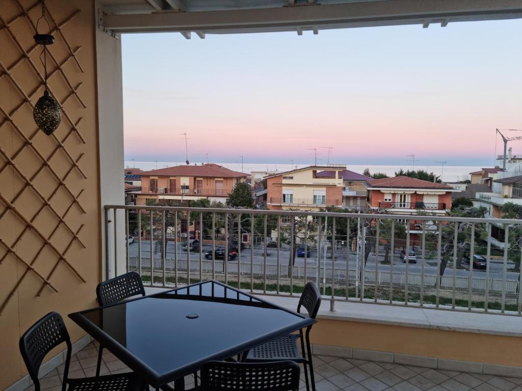 een balkon met een tafel en stoelen en uitzicht op de stad bij CASA FLAN in Porto San Giorgio