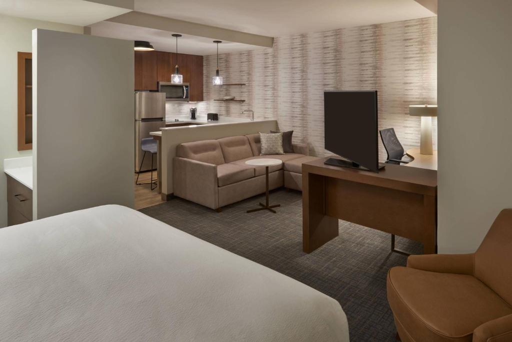 Habitación de hotel con cama y sala de estar. en Residence Inn by Marriott Toronto Mississauga Southwest en Mississauga