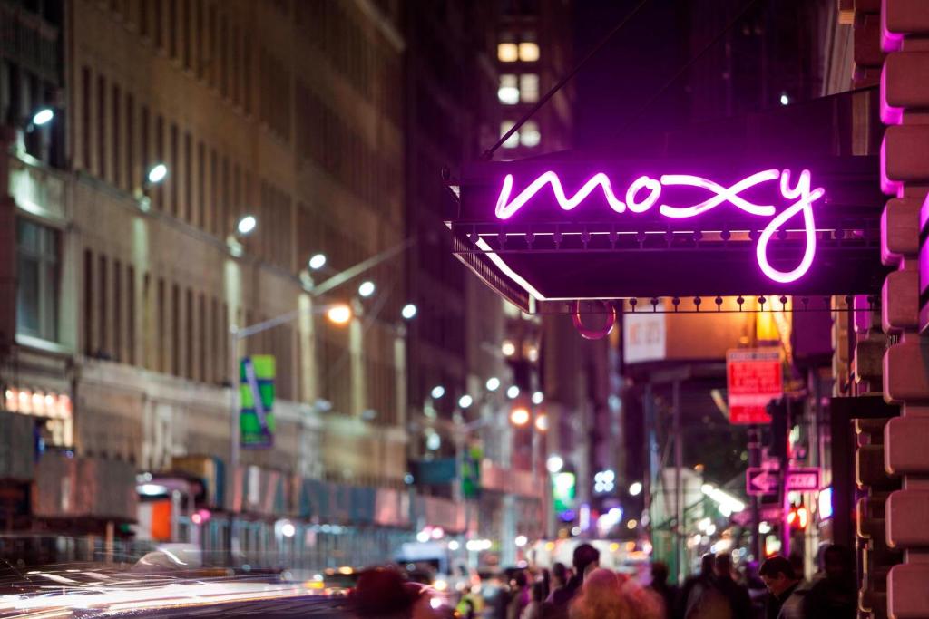 a neon sign on a city street at night at MOXY NYC Times Square in New York