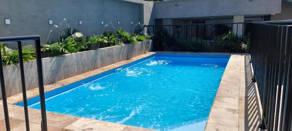 una piscina de agua azul frente a una casa en Hotel San Miguel Imperial, en Santa Marta