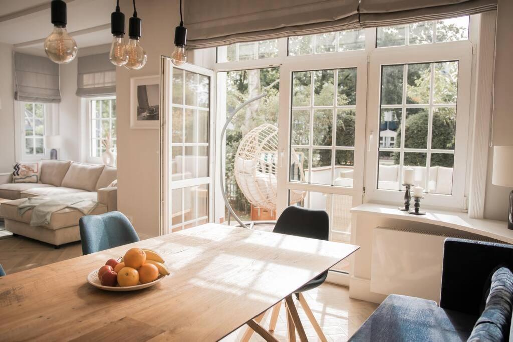 Una sala de estar con una mesa con un bol de fruta encima. en Appartement salt mit Südterrasse, en Timmendorfer Strand