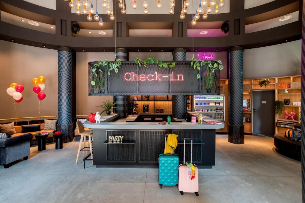 a lobby with a check in counter with luggage at Moxy The Hague in The Hague