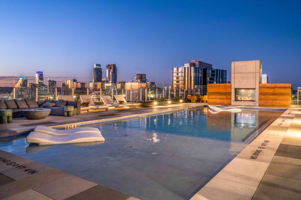 a swimming pool on top of a building with a city skyline at Natiivo in Austin
