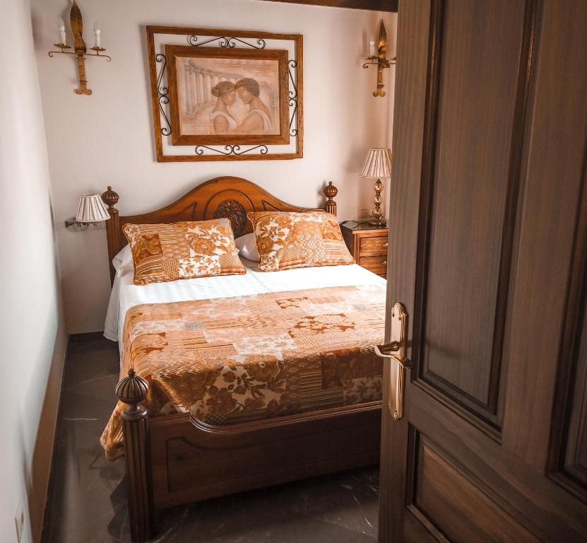 um quarto com uma cama e uma fotografia na parede em Apartamentos en pleno centro, Aljibe Rodrigo del Campo 2C em Granada