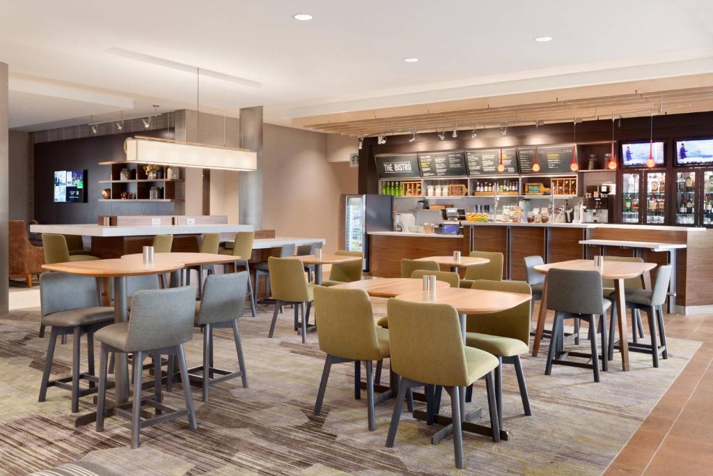 a restaurant with tables and chairs and a bar at Courtyard by Marriott Boston Dedham/Westwood in Westwood