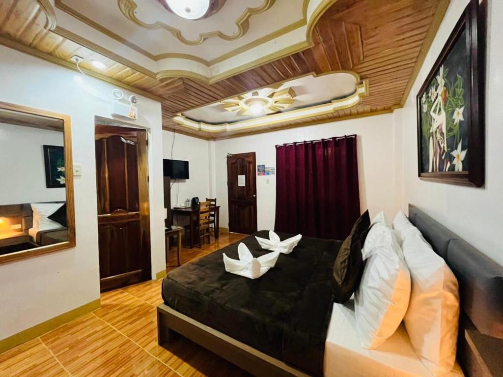 ein Schlafzimmer mit einem großen schwarzen Bett mit weißen Kissen in der Unterkunft Villa Marii in Dipolog City