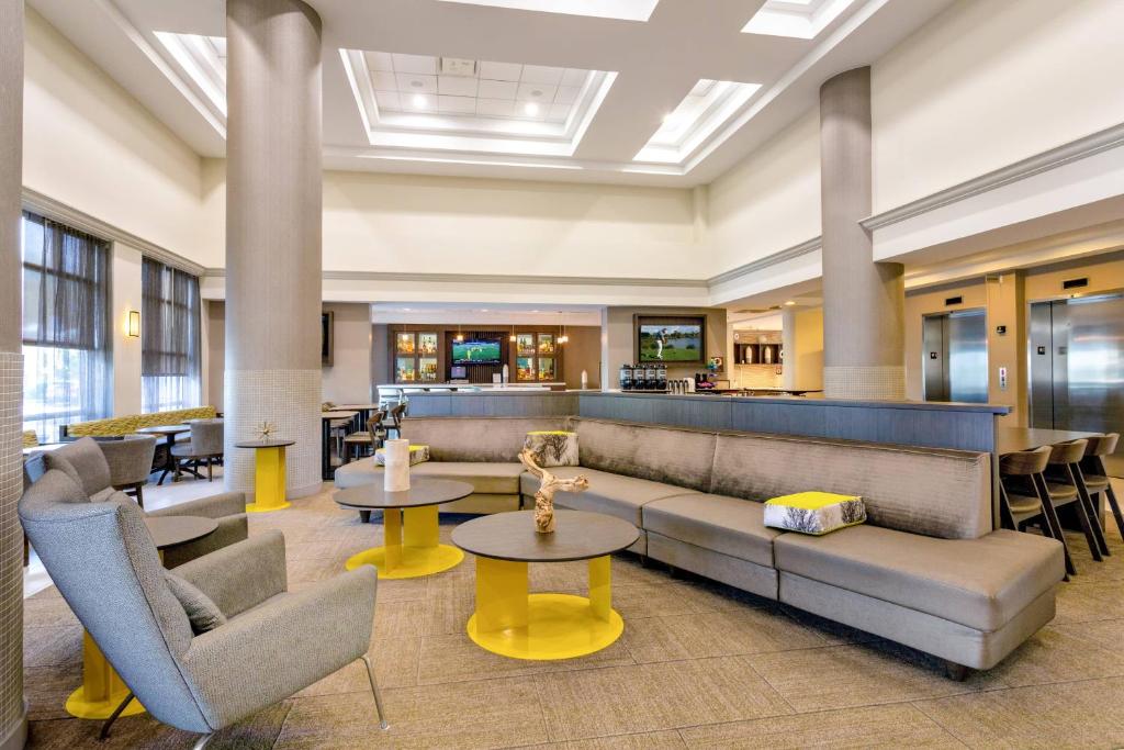 a lobby with couches and tables and a bar at SpringHill Suites by Marriott Miami Airport South Blue Lagoon Area in Miami