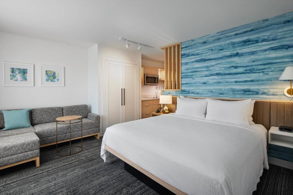タンパにあるTownePlace Suites by Marriott Tampa Casino Areaのベッドとソファ付きのホテルルーム