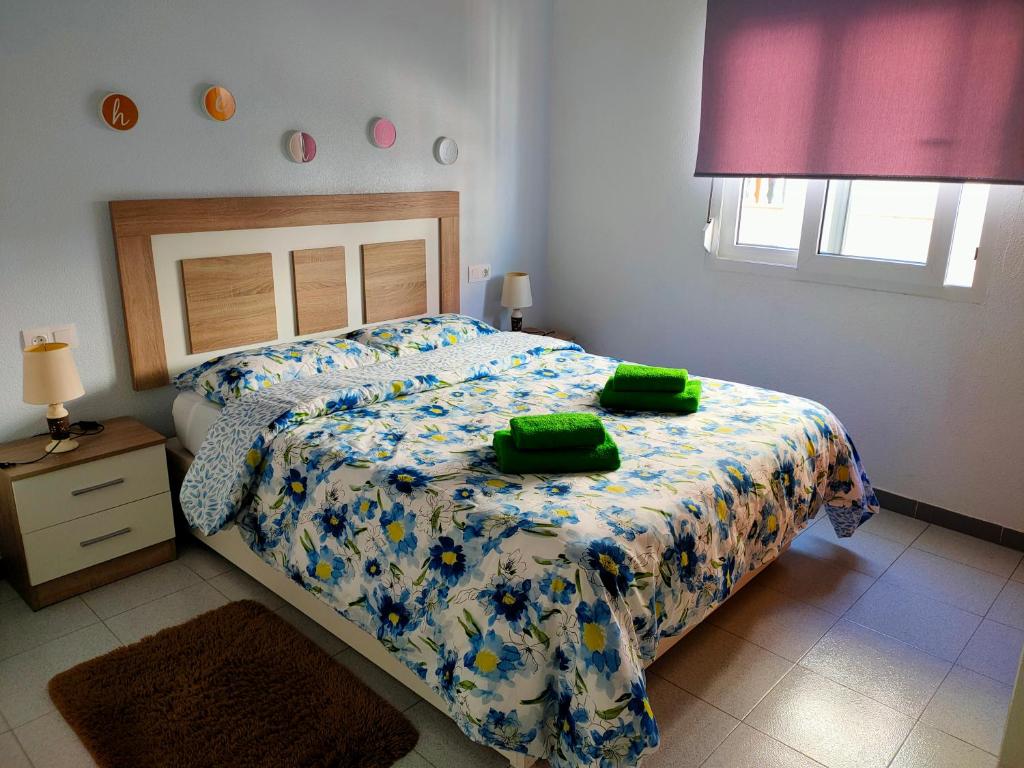 1 dormitorio con 1 cama con toallas verdes en Casas Holiday - playa Acequion, en Torrevieja