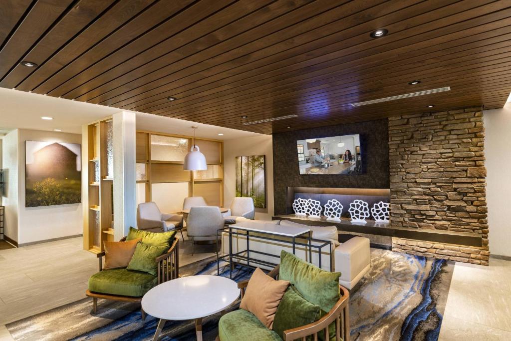 鳳凰城的住宿－Fairfield Inn & Suites by Marriott Phoenix West/Tolleson，大堂设有桌椅和石墙