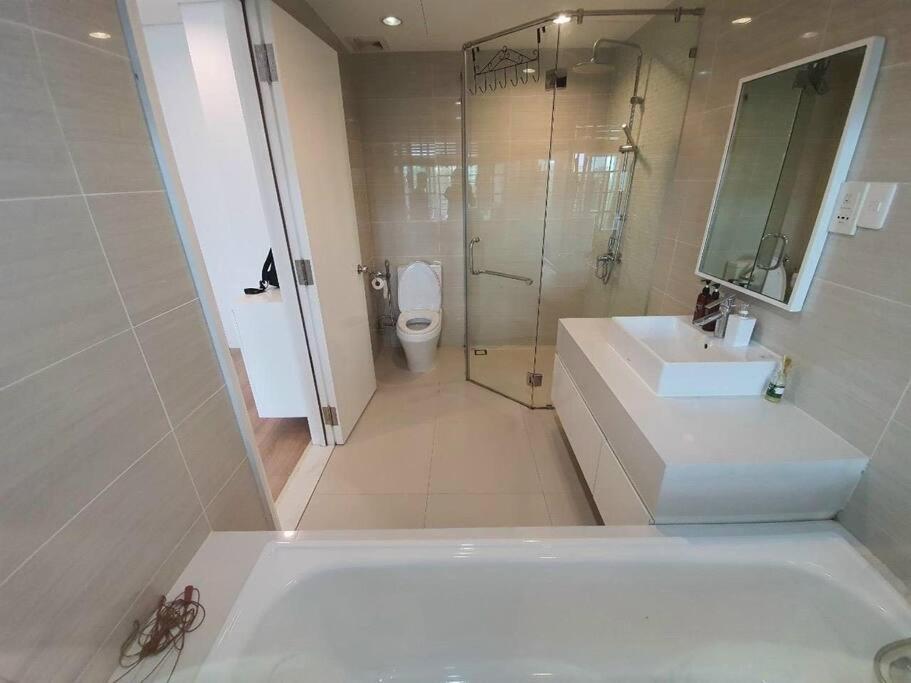 a bathroom with a tub and a sink and a toilet at The Rixx Convenient Apartment @ Ben Thanh/pool/gym in Ho Chi Minh City